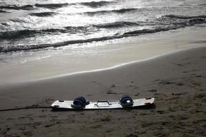 Snowboard auf dem nassen Sand eines Strandes, um Wassersport zu betreiben foto