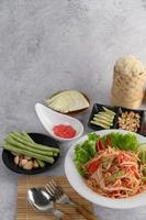 Thai-Salat mit Klebreis, getrockneten Garnelen, Löffel und Gabel foto