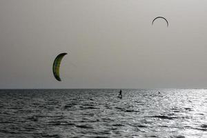 Windsurfen, Kitesurfen, Wasser- und Windsport mit Segeln oder Drachen foto