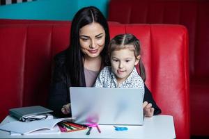 mutter hilft ihrer tochter bei den hausaufgaben. mutter hilft ihrer tochter bei den hausaufgaben. glückliche Kindheit foto