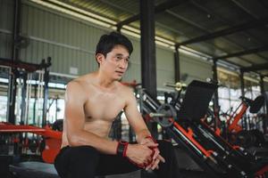 junge männer, die sich nach einem intensiven training im fitnessstudio ausruhen. Fitness gesunder Mann müde nach einem Krafttraining im Fitnessstudio. foto