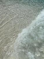 sommerstimmung, hellblaue meereswellen am sauberen sandstrand, hintergrundbild der meerwasseroberfläche im wasser, nahansicht der naturlandschaft, sommerfrühlingsnatur, hintergrund mit kopienraum. foto