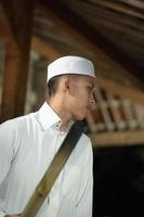 Schöner islamischer Mann mit weißem muslimischem Kleid in der dunklen Nacht foto