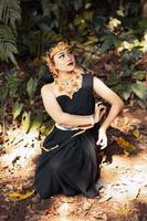 indische frau, die ein schwarzes kleid mit einer goldenen krone und einer goldenen halskette auf ihrem körper trägt foto