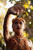 Balinesischer Mann posiert mit ihrer Hand, während er eine goldene Krone und ohne Hemd trägt foto