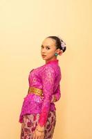 schöne braut von einer balinesischen frau mit rosa kleidern und make-up auf ihrem gesicht foto