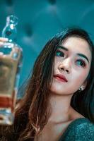 asiatische frauen mit blauen kleidern trinken beim feiern wein direkt aus der flasche foto