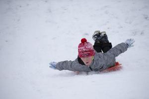 Kind im Winter. Der Junge fährt Schlitten. foto