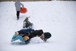 Kinder im Winter. Jungs Freunde sind Rodeln. foto