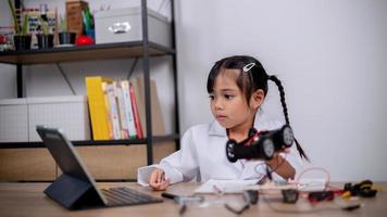 asiatische schüler lernen zu hause, indem sie roboterautos und elektronische platinenkabel in stamm, dampf, mathematik, ingenieurwesen, wissenschaft, technologie, computercode in robotik für kinderkonzepte codieren. foto