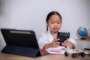 asiatische schüler lernen zu hause, indem sie roboterautos und elektronische platinenkabel in stamm, dampf, mathematik, ingenieurwesen, wissenschaft, technologie, computercode in robotik für kinderkonzepte codieren. foto