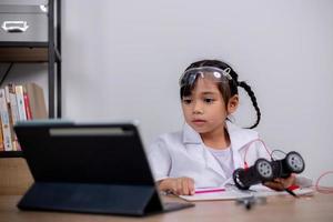 asiatische schüler lernen zu hause, indem sie roboterautos und elektronische platinenkabel in stamm, dampf, mathematik, ingenieurwesen, wissenschaft, technologie, computercode in robotik für kinderkonzepte codieren. foto