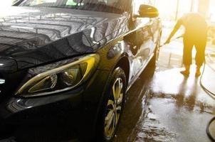 schwarzes Auto wird gewaschen