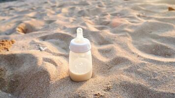 Milchflasche auf dem Strandsand bei Sonnenuntergang foto