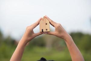 neues hauskonzept - junge familie mit modell im maßstab des traumhauses in den händen foto