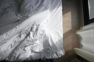 Draufsicht auf unordentliches Bett am frühen Morgen, unordentliches Bett nach dem Aufwachen foto