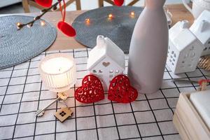 Schlüssel zum Haus des gemütlichen Zuhauses mit Valentinsdekor auf dem Küchentisch. geschenk zum valentinstag, familienliebesnest. Bau, Design, Projekt, Umzug in ein neues Haus, Hypothek, Miete und Kauf von Immobilien foto