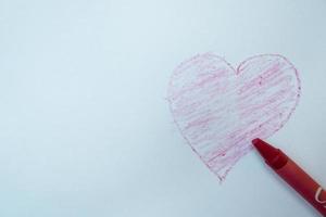Selektiver Fokus auf das Liebessymbol, das mit Buntstiften von Hand gezeichnet wurde, weicher Fokus foto