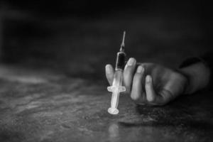 Hand einer jungen Frau, die eine Spritze und eine Überdosis Drogen hält, das Konzept der Kriminalität und Drogenabhängigkeit. 26. Juni, internationaler Tag gegen Drogenmissbrauch. foto