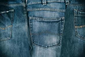 Mehrere blaue klassische Jeans, die hintereinander gefaltet sind foto