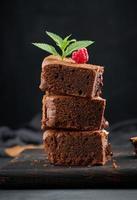 Gebackene Schokoladenbrownie-Torte auf schwarzem Tisch, leckeres Dessert foto