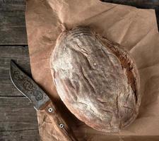 gebackenes knuspriges ovales Brot und Vintage-Messer foto