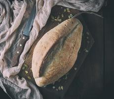 gebackenes knuspriges ovales Brot und Vintage-Messer foto