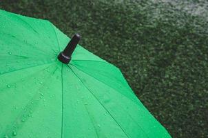 grüner Regenschirm mit Regentropfen foto