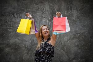 Porträt einer jungen glücklichen lächelnden Frau mit Einkaufstüten foto