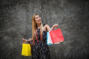 Porträt einer jungen glücklichen lächelnden Frau mit Einkaufstüten foto