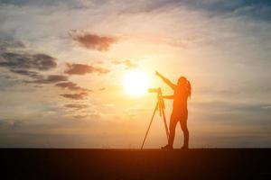 Silhouette eines Fotografen, der bei Sonnenuntergang schießt foto