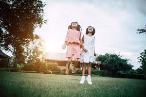 zwei kleine Mädchen, die Spaß haben, im Park zu spielen foto