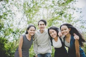 glückliche jugendliche Freunde, die draußen in einem Park lächeln foto