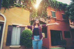 glückliche junge Frau, die ihre Reisen genießt und ihre Hände in die Luft hebt foto