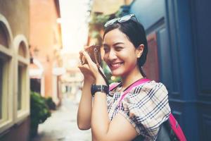 Nahaufnahme einer jungen Hipsterfrau, die reist und Fotos mit ihrer Kamera macht