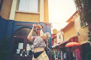 junge Hipsterfrau, die Fotos in einem städtischen Gebiet macht