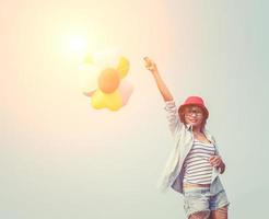 junge schöne Frau, die Luftballons in der frischen Luft hält foto