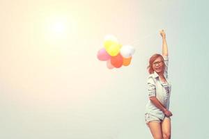 junge schöne Frau, die Luftballons in der frischen Luft hält foto