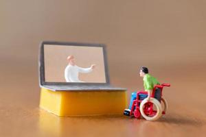 männliche Figur Patient Beratung mit Arzt mit Videoanruf auf Laptop foto