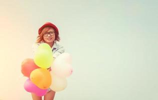 junge schöne Frau, die Luftballons in der frischen Luft hält foto