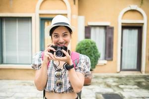 Porträt der hübschen jungen Hipsterfrau, die Spaß in der Stadt mit Kamera hat