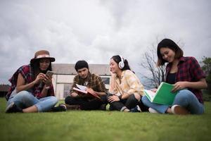 Gruppe von Studenten, die nach dem Unterricht in einem Park sitzen foto