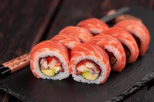 Sushi-Rolle Maguro mit Thunfisch, geräuchertem Aal, Avocado, Philadelphia-Käse auf Tafel Nahaufnahme. Sushi-Menü. japanisches Essen. foto