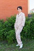 Fröhliche Frau im Haus tragen Pyjama im Freien Mauer Hinterhof Hintergrund Emotionen - Nachtwäsche und Homewear-Konzept foto