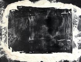 weißes Weizenmehl auf einem schwarzen Tisch verstreut foto