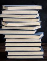 Stapel Bücher in einem blauen Einband auf einem braunen Holztisch foto