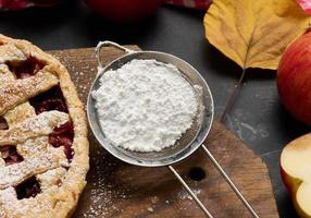 Eisensieb mit Puderzucker und gebackenem runden Kuchen foto