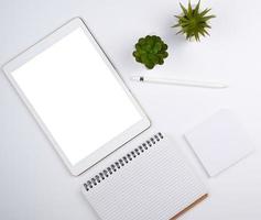 Weißes elektronisches Tablet mit leerem Bildschirm und Bleistift foto