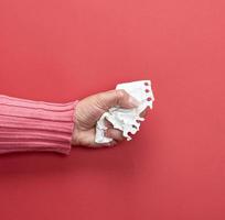 weibliche hand, die ein weißes zerknittertes blatt papier hält foto