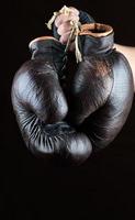 hand hält ein paar alte braune boxhandschuhe aus leder foto